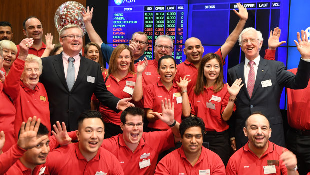 Coles managing director Steven Cain (in suit, left) and chairman James Graham (right) with Coles staff at its ASX listing ceremony on Wednesday. 