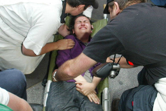 Karvelas is stretchered away after being trampled by a police horse during a 2002 anti-globalisation protest.