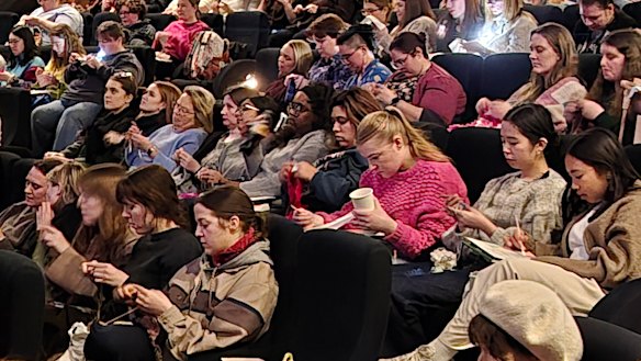 A scene from a recent Craft Cinema Night held at the Classic Cinema Elsternwick. The privately-run events, where lights are kept on, allow the audience to work on knitting and colouring projects while a retro movie plays in the background.  