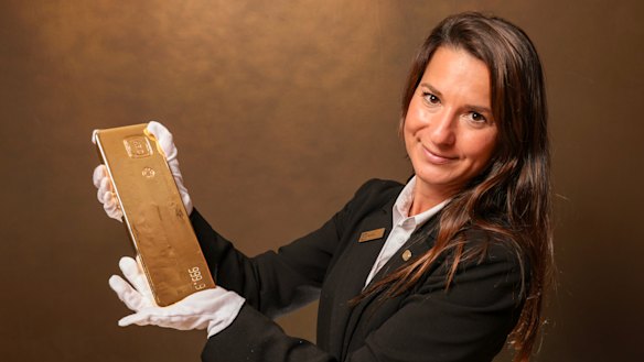 Agata Pawlak with a 400oz gold cast bar at ABC Bullion in Sydney. Photo: Dylan Coker / The Sydney Morning Herald