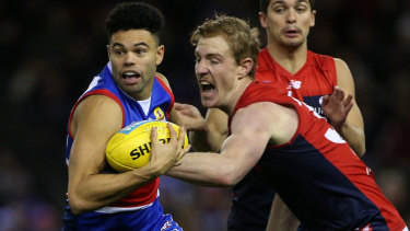 Jason Johannisen of the Western Bulldogs fends off Melbourne's Harrison Petty in round 17.