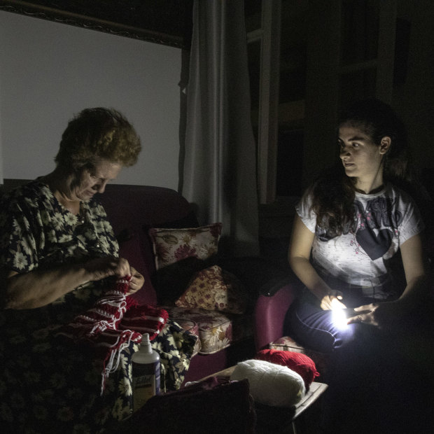 Residents sitting in torchlight during Beirut’s nightly power cuts. Some places will get electricity for only an hour or two a day. 