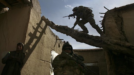 Australian soldiers search a house for weapons, explosives and Taliban fighters during a foot patrol in Chora, Afghanistan, in 2009.