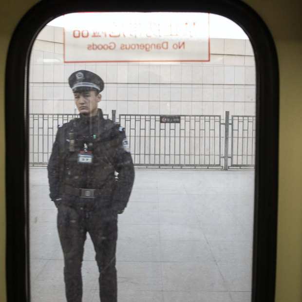 A police officer seen through a train window in Turpan, Xinjiang, in 2018.