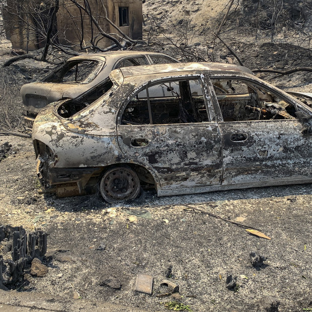 Rodos adasında çıkan bir orman yangınından sonra yolda arabaların parçalanmış kalıntıları yatıyor.