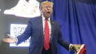 Donald Trump holds gold Trump sneakers at Sneaker Con Philadelphia, an event popular with sneaker lovers.