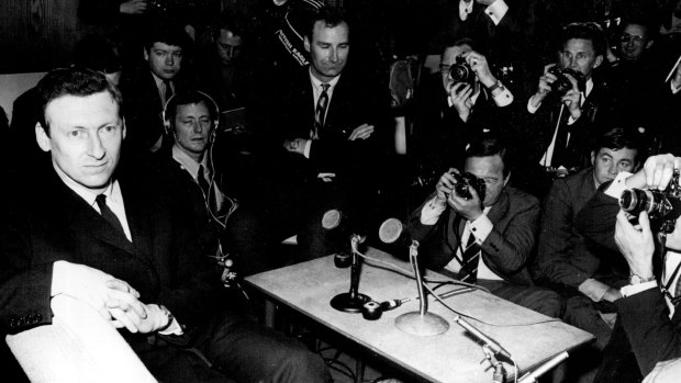 Looking pale and tense, Anthony Grey faces a barrage of photographers after arriving at London Airport in 1969.