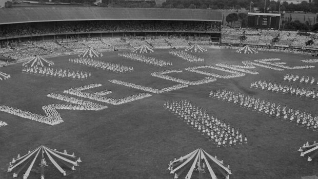 Schoolchildren form the word WELCOME during their spectacular demonstration for the Queen Mother at the Melbourne Cricket Ground