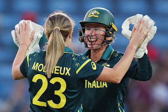 Sophie Molineux and Beth Mooney (right) celebrate a wicket, but Mooney has a hand injury.