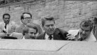  Ronald Reagan waves and then looks up before being shoved into the President’s limousine by secret service agents after being shot outside a Washington hotel, March 30, 1981.