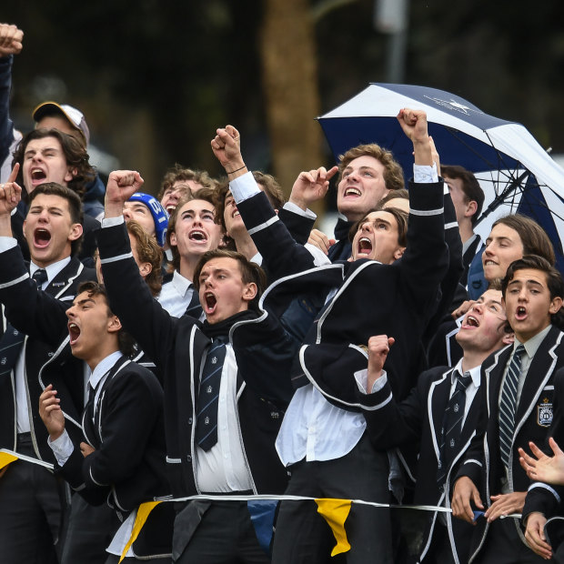 School ties: Caulfield Grammar students cheer a goal against Carey Grammar in the APS grand final.