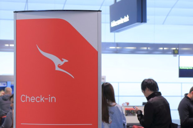 Mackay Havalimanı'nda Qantas check-in kontuarında insanlar sırada bekliyor.
