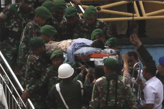 Soldiers carry Wiranto on a stretcher to a waiting helicopter to be evacuated to Jakarta.