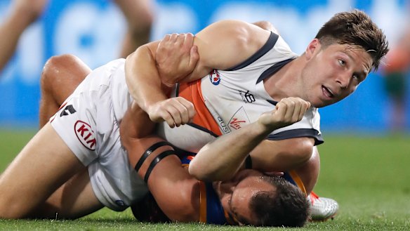 Toby Greene wrestles with Brisbane's Luke Hodge during Saturday night's final at The Gabba.