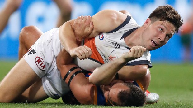 Toby Greene wrestles with Brisbane's Luke Hodge during Saturday night's final at The Gabba.