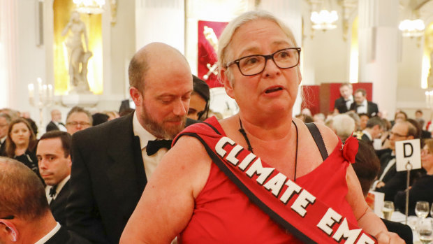 A climate change protester walks through the dining tables during the annual Bankers and Merchants Dinner during Philip Hammond, UK chancellor of the exchequer's speech at The Mansion House in London, UK.