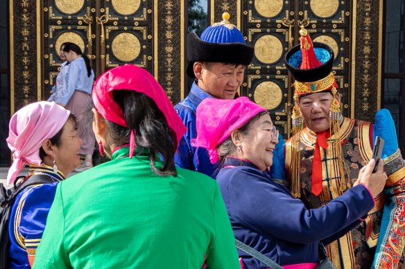 People take selfies in front of a museum in Mongolia’s capital.