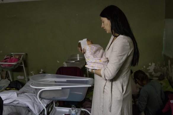 A mother holds her newborn baby in the bomb shelter of a maternity hospital in Kyiv, Ukraine, on Wednesday.