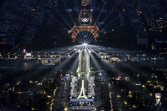 The Eiffel Tower and the Olympics rings are lit up.