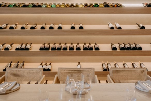 The cavernous dining room is lined with wine bottles. 