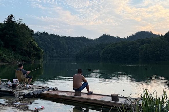 Local villagers fish from the reservoir in Xingming village.