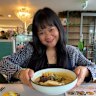 Rifa Fitriana enjoying a bowl of soto Betawi iga bakar, a Jakarta-style beef soup, at Kayu Manis.