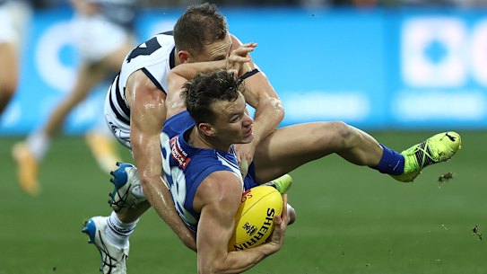 Joel Selwood throws everything at North’s Kayne Turner. 