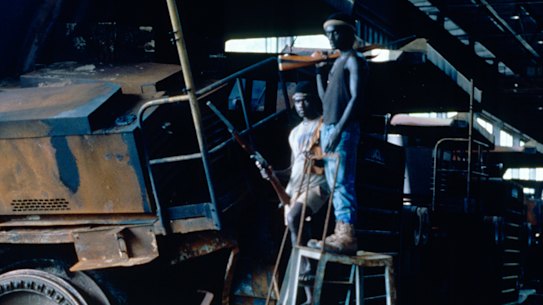 Bougainville Revolutionary Army guerillas stand next to a destroyed dump truck inside the captured Panguna mine in 1994.