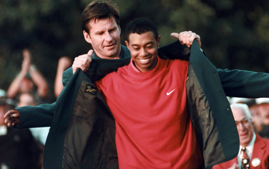 Where it all began: Nick Faldo presents Tiger Woods with his first green jacket in 1997.