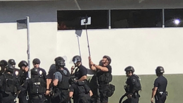 Police officers use a mirror to see inside a Trader Joe's store in the Silver Lake neighbourhood of Los Angeles on Saturday.