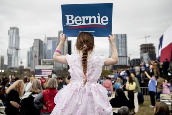Lily Barbour, 5, holds up a campaign sign for Democratic presidential candidate Bernie Sanders.