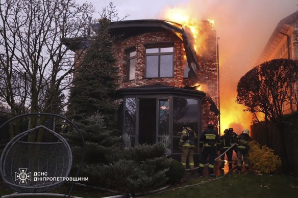 Rescue workers put out a fire of a burning house damaged by a Russian strike on Dnipro, Ukraine.