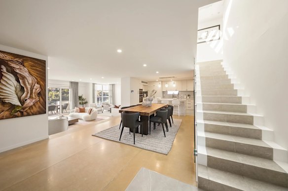 The three-level residence features polished concrete floors, a dramatic entry staircase and bifold doors. 
