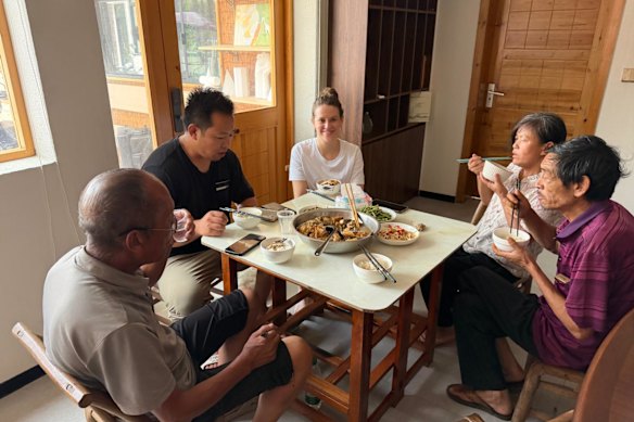 North Asia correspondent Lisa Visentin has lunch with Li Zhiying's family and neighbors at the guesthouse in Xingming village.