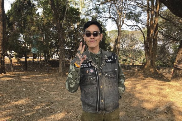 Political activist Mongkhon Therakot shows three pro-democracy fingers before going to court.