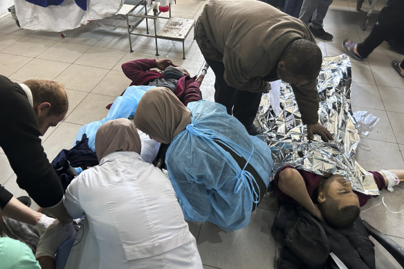 Palestinians wounded in an Israeli strike while waiting for humanitarian aid on the beach in Gaza City are treated in Shifa Hospital.