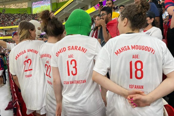 Katar'daki İran - ABD maçında Pussy Riot kolektif üyeleri, İran'daki protestolar sırasında öldürülen gençlerin isimlerini gösteriyor. 