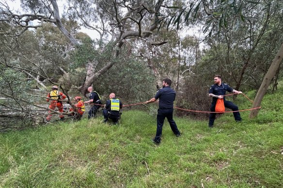 Police and SES crew work to rescue a woman and her dog in Werribee on Boxing Day.
