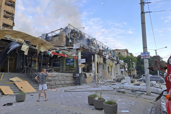 A man stands on a street in front of Ria Pizza, which was destroyed by a Russian attack.