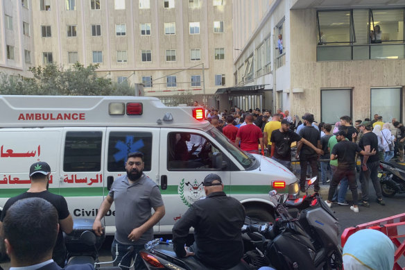 People gather outside the American University hospital after the arrival of several men who were wounded by exploded handheld pagers in Beirut, Lebanon.