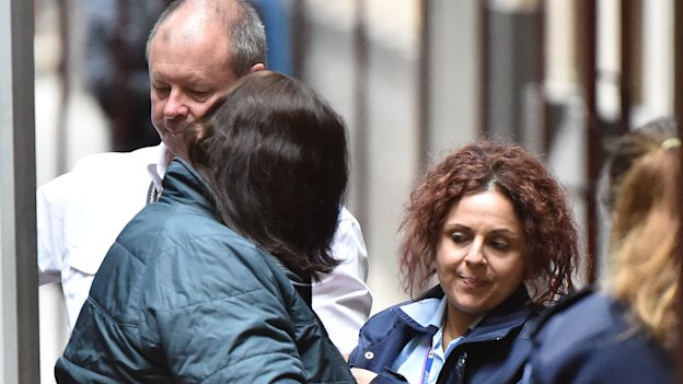 Katia Pyliotis, her face hidden by her hair, arrives at the Supreme Court in Melbourne in April 2019.