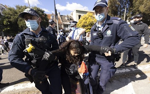 Police arrest a woman on Broadway during a large Anti-lockdown protest in Sydney 24 July, 2021. Photo: Brook Mitchell