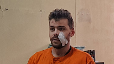 Nicholas Carr at Kuta police station in a police prisoner orange jumpsuit.