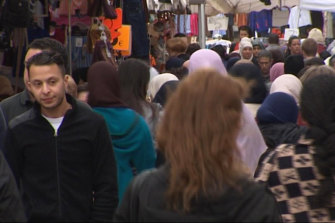 Salah Abdeslam, left, walking through a market in Brussels in 2016, is one of 20 people on trial for the 2015 Paris attacks.