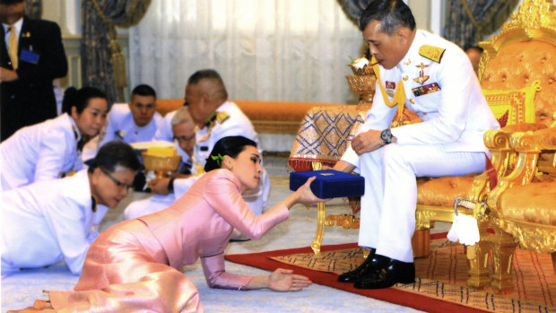 King Maha Vajiralongkorn presents a gift to Queen Suthida Vajiralongkorn Na Ayudhya at Ampornsan Throne Hall in Bangkok.