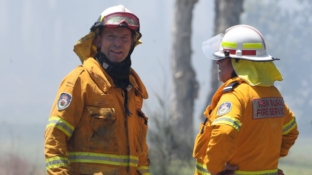 Former prime minister Tony Abbott (left) is seen with his Davidson Brigade as NSW Rural Fire Service crews battle a bush fire burning near houses along Lemon Tree Passage Road.