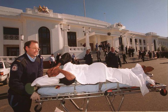 An injured protestor is stretchered to an ambulance.
