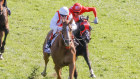 Craig Williams (red and white) riding Giga Kick to victory in The Everest.