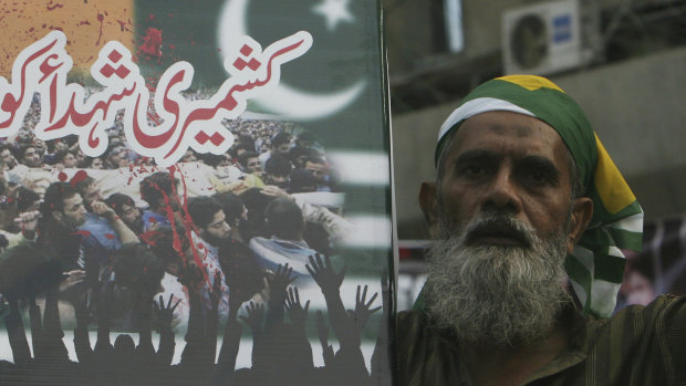 A Pakistani holds a placard that reads, "salute to Kashmiri martyrs," during an anti-Indian protest in Karachi, Pakistan.