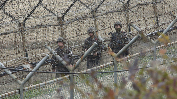 South Korean army soldiers patrol along the barbed-wire fence in Paju, South Korea, on Friday.